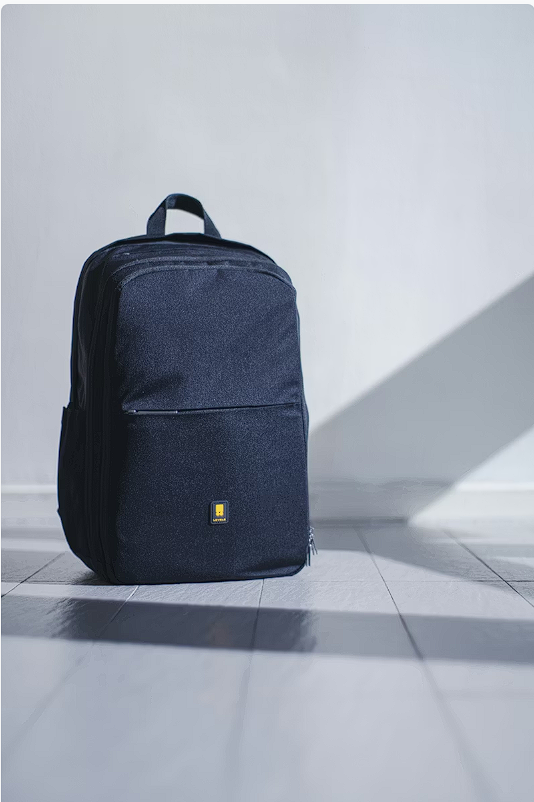 Tan leather backpack on a wooden surface