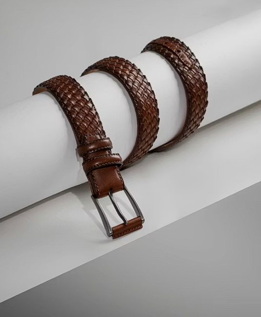 Brown leather belt coiled on white background