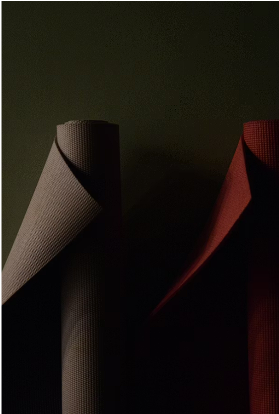 Rolled yoga mat on a studio floor